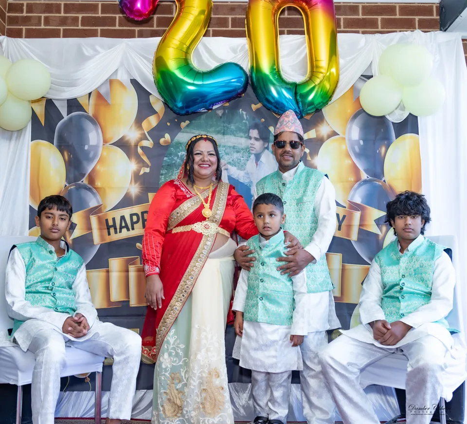 A family gathered beneath gold celebration balloons