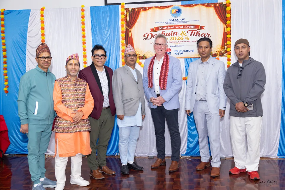 Friends gathered in front of a Dashain and Tihar celebration backdrop